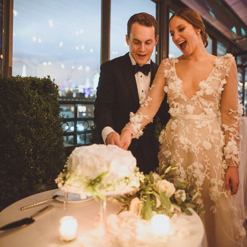 Bride in Marchesa dress with groom cutting the wedding cake