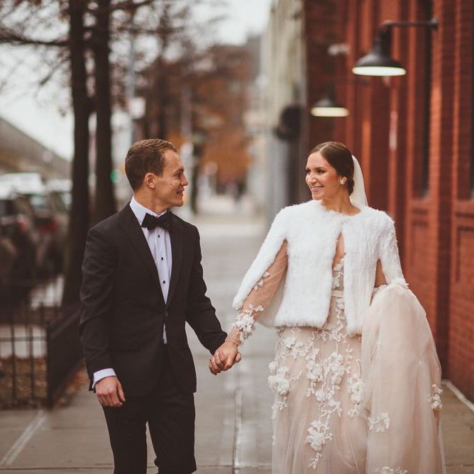 Bride wears cover up over Marchesa bridal gown