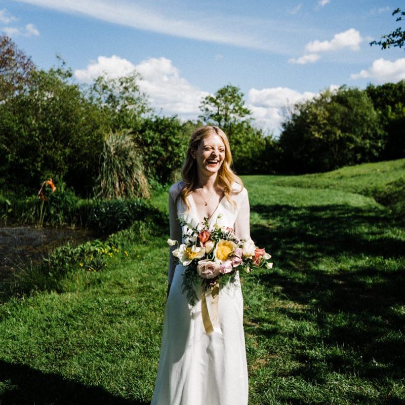 Beautiful Bride in Andrea Hawkes Wedding Dress Holding a Spring Bouquet