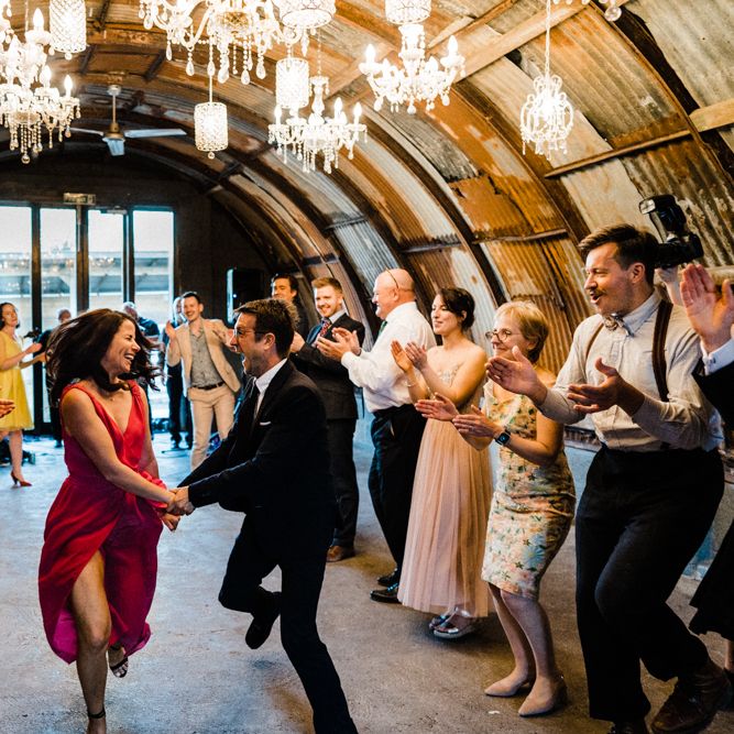 Wedding Guests Dancing Under a Ceiling of Chandeliers