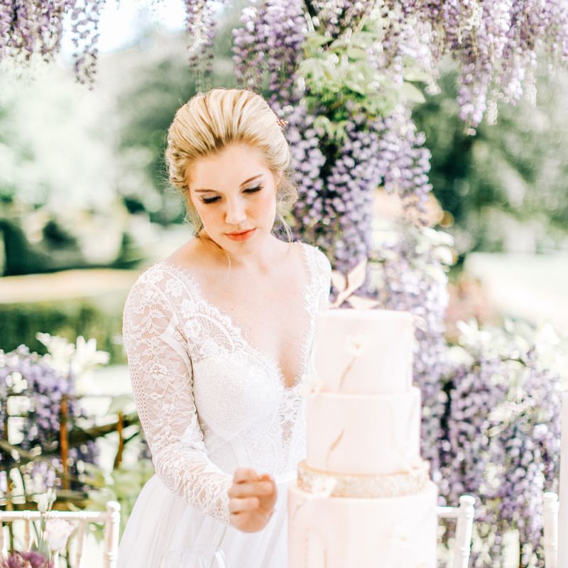 Bride Looking at Marble Effect Wedding Cake with Gold Glitter Layer
