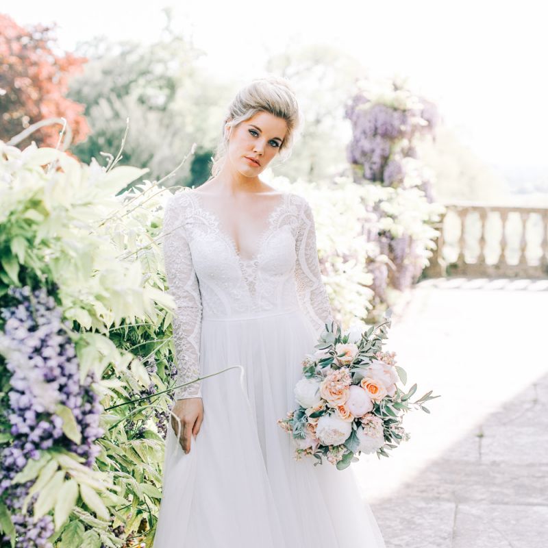 Bride in Lace and Tulle Wedding Dress Holding a Peach and White Wedding Bouquet