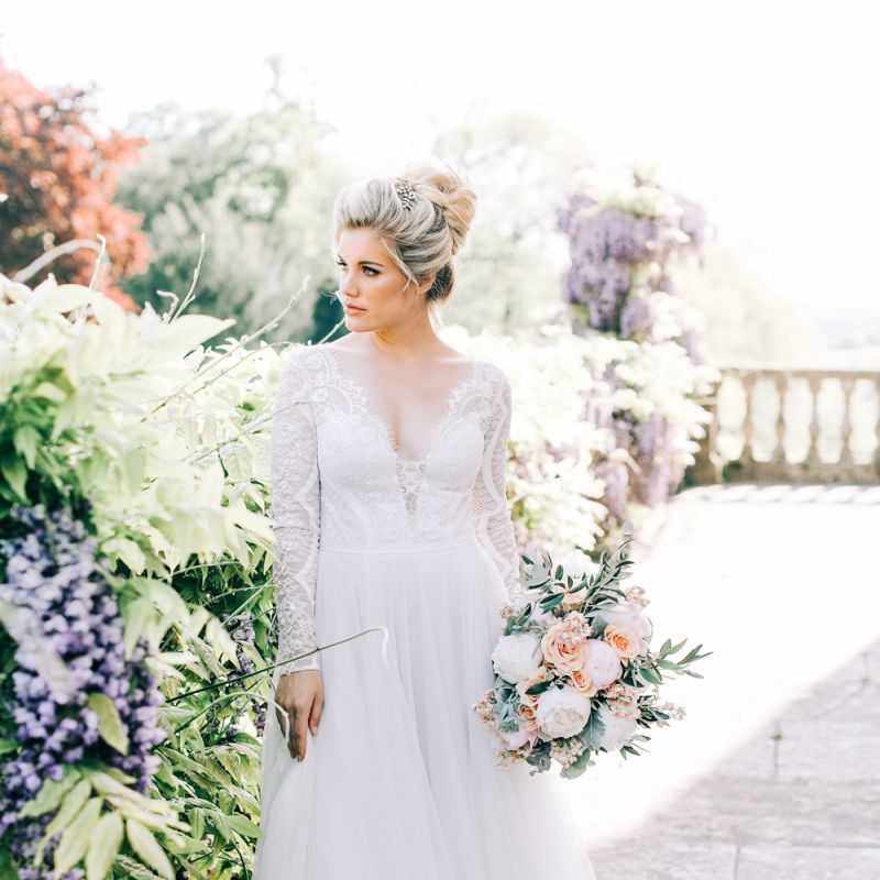Bride in Lace and Tulle Wedding Dress Holding a Peach and White Wedding Bouquet