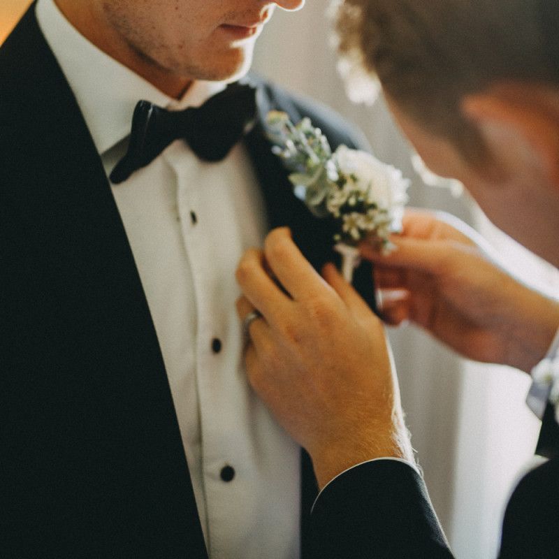 Groom in black tuxedo with white floral buttonhole