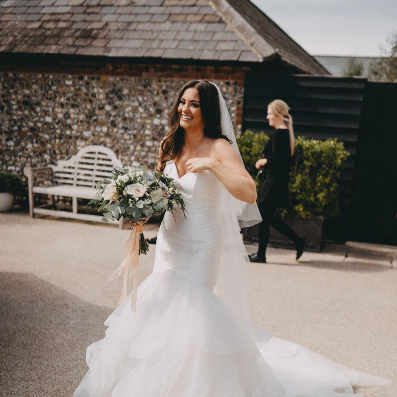 Strapless fishtail wedding dress with blush bouquet