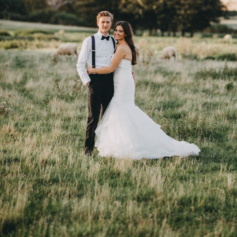 Bride in strapless fishtail wedding dress with groom in tuxedo