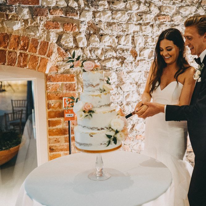 Bride and groom cut wedding cake