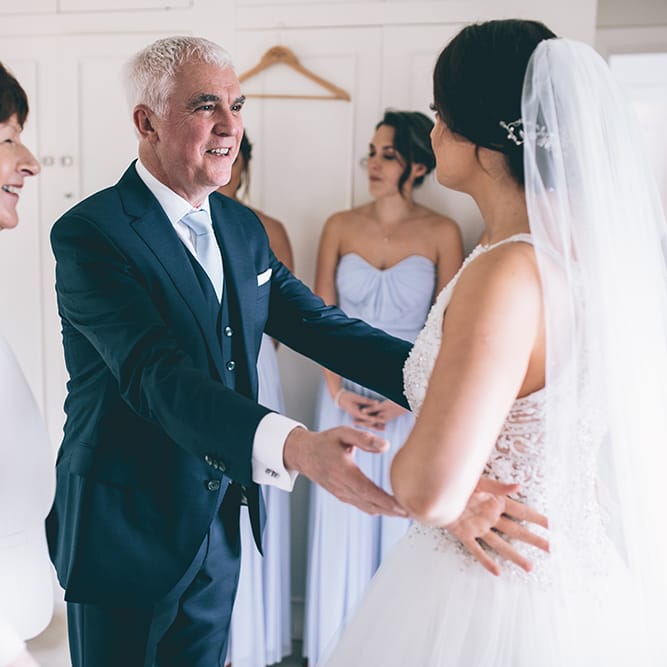 Father of the Bride First Look | Beaded Halterneck Bridal Gown with Tulle Skirt and Spaghetti Straps by Maggie Sottero | Hair Vine from Etsy | Floor Length Veil | Pastel Blue Bridesmaids Dresses from ASOS | Father of the Bride in Navy Blue Suit with Pastel Blue Tie | Halterneck Maggie Sottero Dress and Garden Games at Gate Street Barn | Story + Colour Photography
