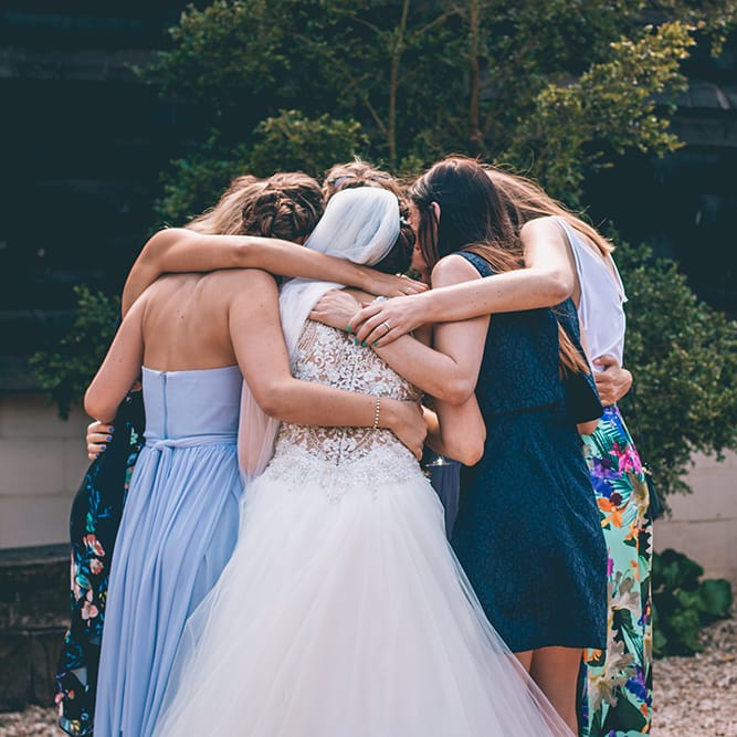 Group Hug | Bride in Beaded Halterneck Gown with Tulle Skirt and Spaghetti Straps by Maggie Sottero | Full Length Veil | Halterneck Maggie Sottero Dress and Garden Games at Gate Street Barn | Story + Colour Photography