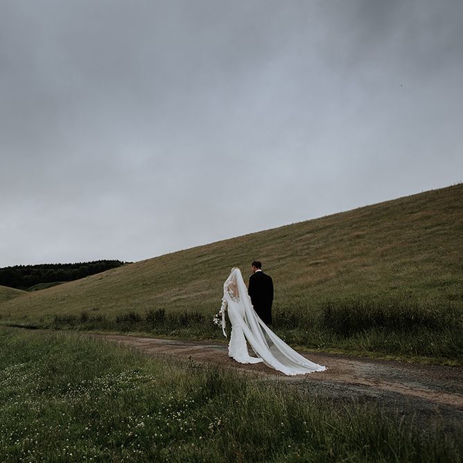 Bride and Groom In Countryside with Veil