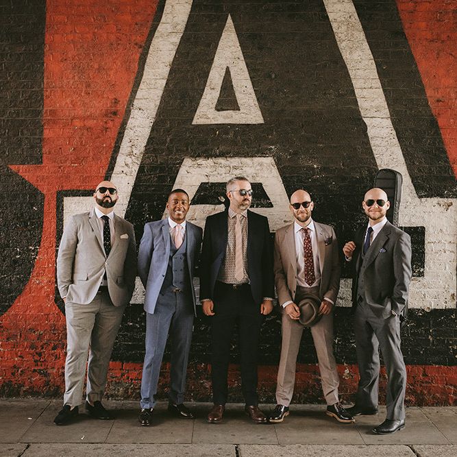 Groom and Groomsmen | Groom in Grey Puppy Tooth Check Two-Piece Paul Smith Suit with Amber Tie Pin, Pocket Square, Braces and Hat with Feather | Bike Shed Motorcycle Club Wedding for ELLE Digital Editor | Nigel John Photography