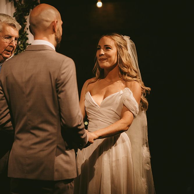 Wedding Vows | Bride in  Bespoke Wedding Gown with Blush Underskirt and One Off Shoulder Strap | Fingertip Length Veil Customised with Feathers | Groom in Grey Puppy Tooth Check Two-Piece Paul Smith Suit with Amber Tie Pin, Pocket Square and Braces | Bike Shed Motorcycle Club Wedding for ELLE Digital Editor | Nigel John Photography