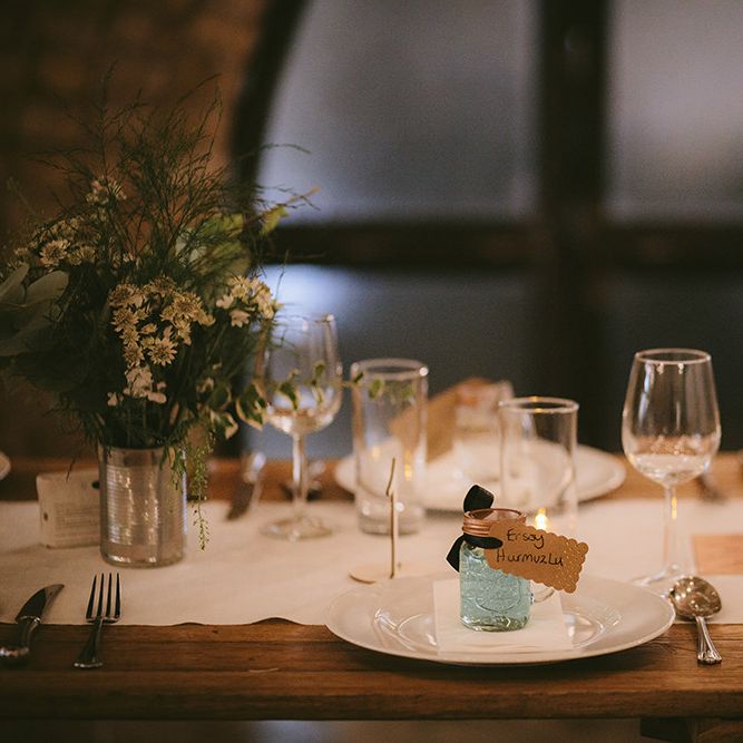 Wedding Reception Décor | Place Setting | Wooden Trestle Tables with White Runner | White Flowers, Ferns and Foliage in Tin Can | Bike Shed Motorcycle Club Wedding for ELLE Digital Editor | Nigel John Photography