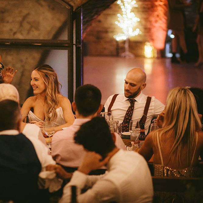 Wedding Reception Speeches | Bride in Bespoke Wedding Gown with Blush Underskirt and One Off Shoulder Strap | Half Up Half Down Bridal Hair | Groom in Grey Puppy Tooth Check Two-Piece Paul Smith Suit with Amber Tie Pin, Pocket Square and Braces | Bike Shed Motorcycle Club Wedding for ELLE Digital Editor | Nigel John Photography