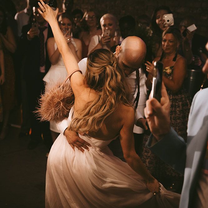 First Dance | Bride in Bespoke Wedding Gown with Blush Underskirt and One Off Shoulder Strap | Half Up Half Down Bridal Hair | Groom in Grey Puppy Tooth Check Two-Piece Paul Smith Suit with Amber Tie Pin, Pocket Square and Braces | Bike Shed Motorcycle Club Wedding for ELLE Digital Editor | Nigel John Photography