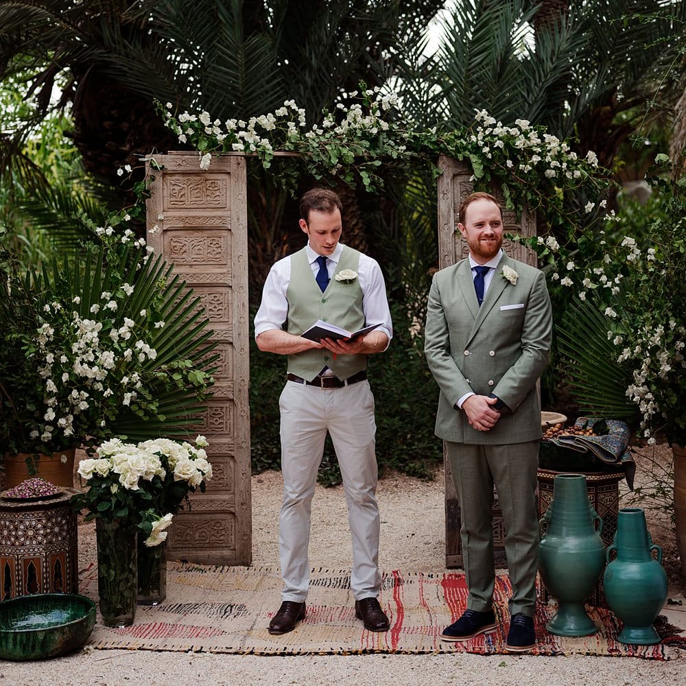 Outdoor Wedding Ceremony | Wooden Door Altar Decor | Groom in Green Beggars Run Suit |  Paradise Destination Wedding at Jnane Tamsna in Marrakech, Morocco | Nordica Photography | Matteo Castelluccia Film