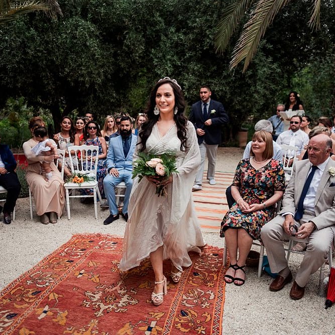 Outdoor Wedding Ceremony | Moroccan Rugs Aisle Wedding Decor | Bride in Rue de Seine Bridal Gown | Paradise Destination Wedding at Jnane Tamsna in Marrakech, Morocco | Nordica Photography | Matteo Castelluccia Film