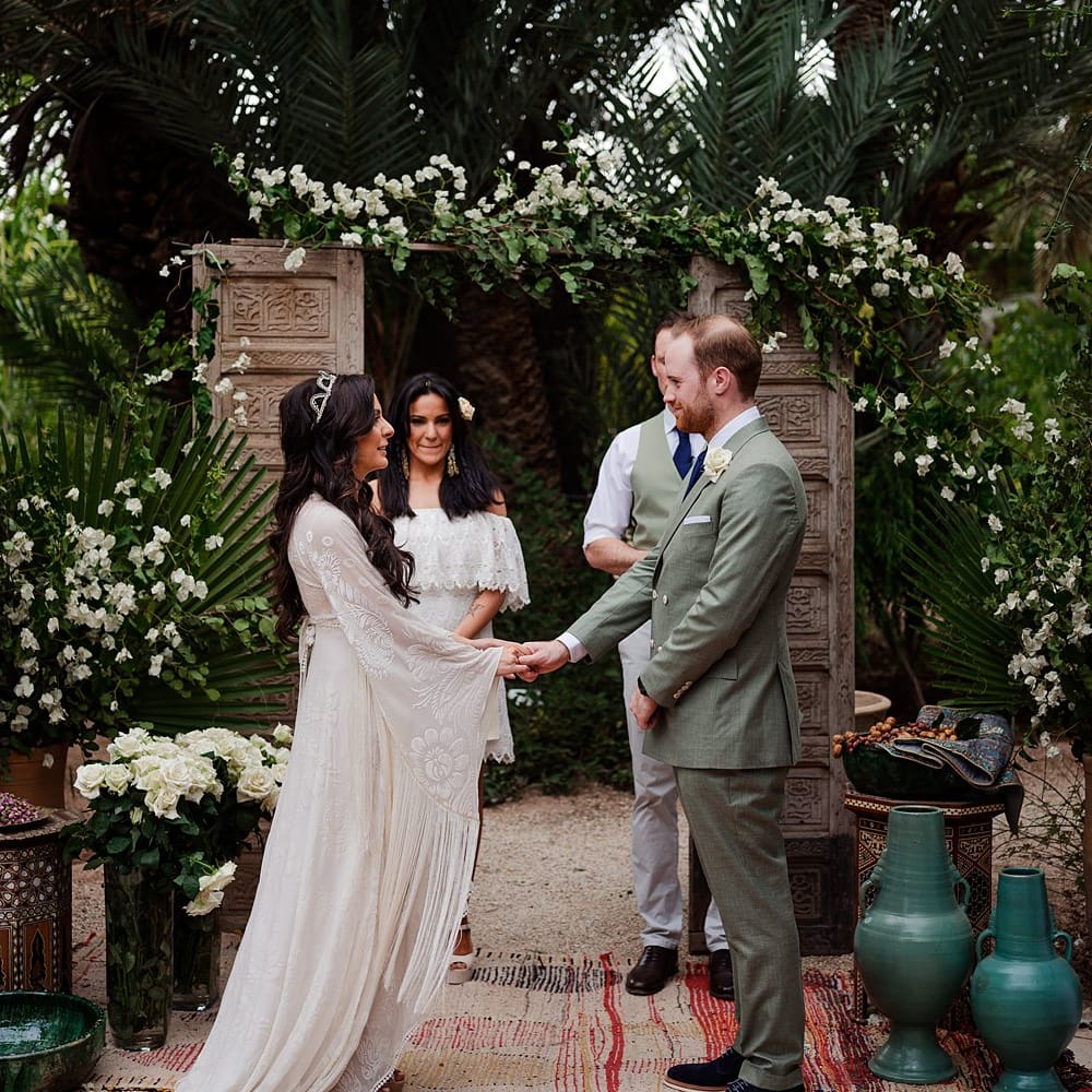 Outdoor Wedding Ceremony | Moroccan Rugs, Wooden Door Altar Wedding Decor | Bride in Rue de Seine Bridal Gown | Groom in Green Beggars Run Suit | Paradise Destination Wedding at Jnane Tamsna in Marrakech, Morocco | Nordica Photography | Matteo Castelluccia Film
