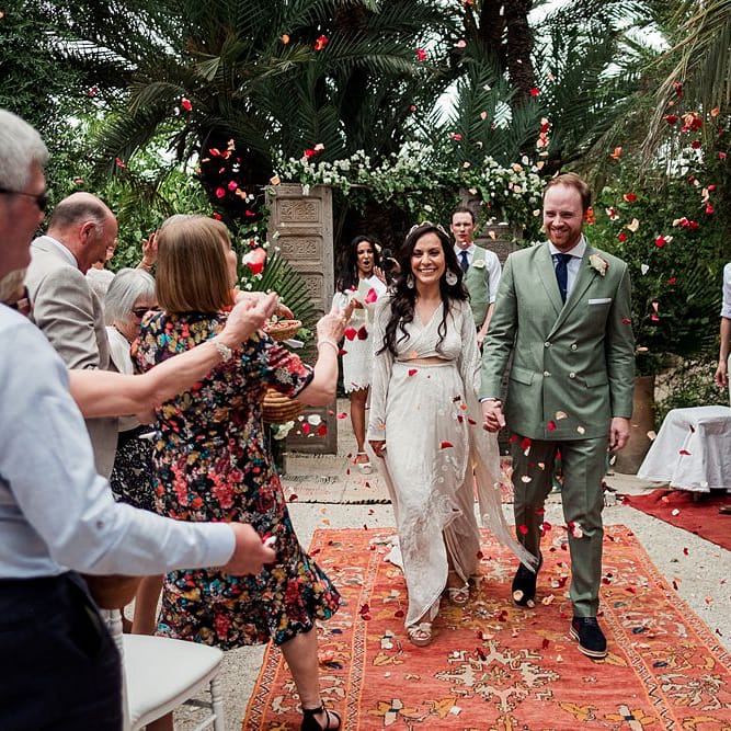 Outdoor Wedding Ceremony | Moroccan Rugs, Wooden Door Altar Wedding Decor | Bride in Rue de Seine Bridal Gown | Groom in Green Beggars Run Suit | Paradise Destination Wedding at Jnane Tamsna in Marrakech, Morocco | Nordica Photography | Matteo Castelluccia Film