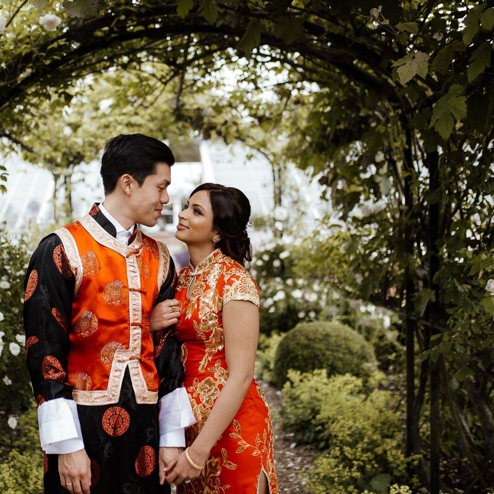 Bride and groom in traditional outfits for Chinese tea ceremony at fusion wedding