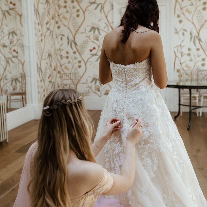Bride in white strapless bride dress before outfit change into Indian wedding dress