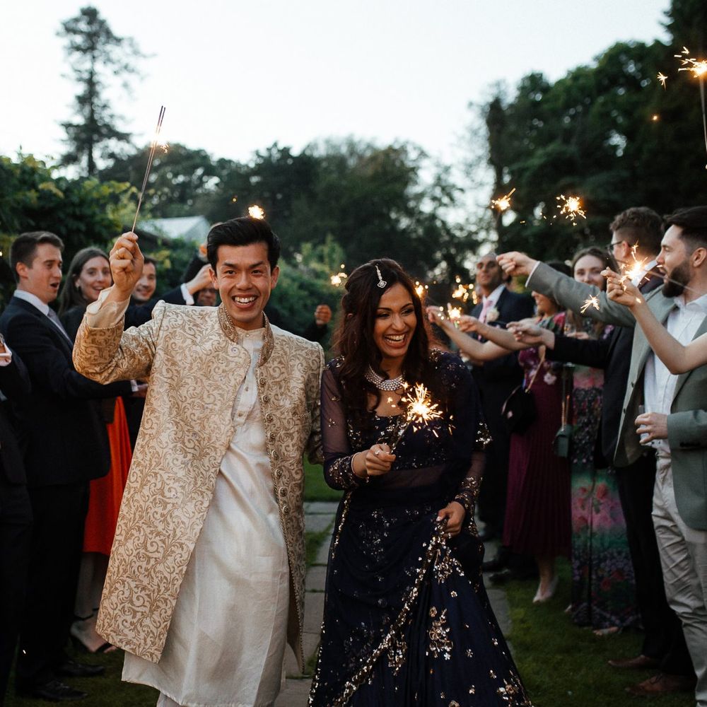 Sparkler exit for groom and bride in traditional Indian wedding dress