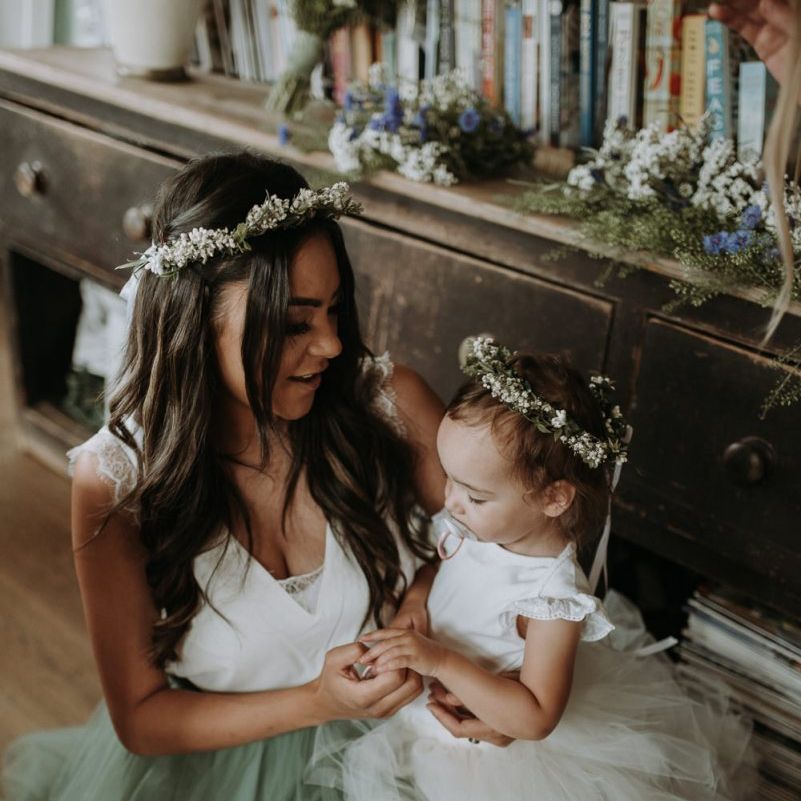 Bridesmaid in blue tulle skirt holding the flower girl