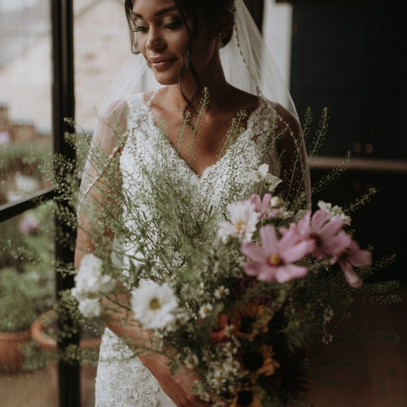 Bride holding her wildflower bouquet on wedding morning