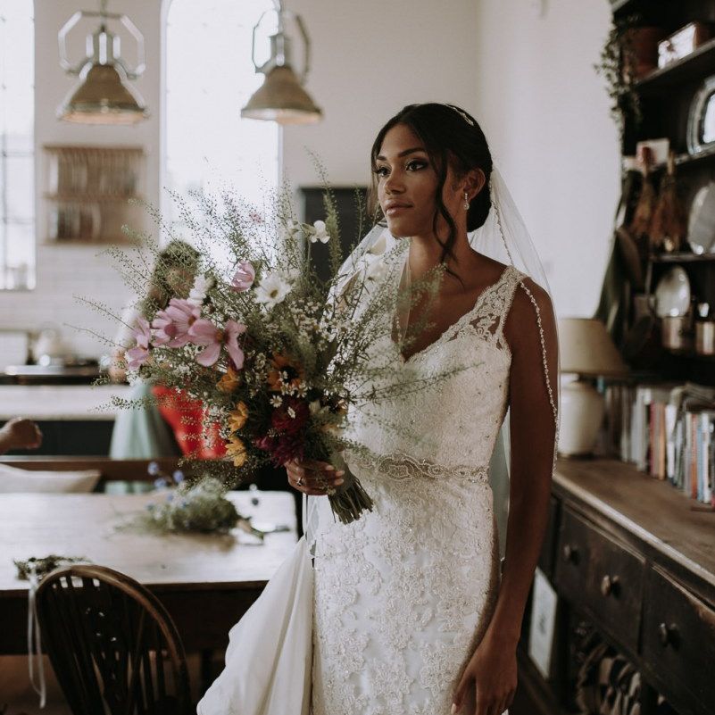 Stunning bride standing in the kitchen on the wedding morning of home garden wedding