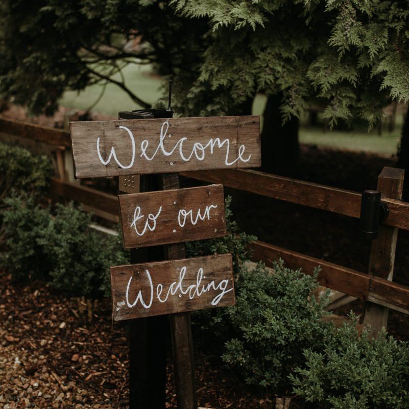 DIY wooden welcome sign at home using garden for wedding ceremony