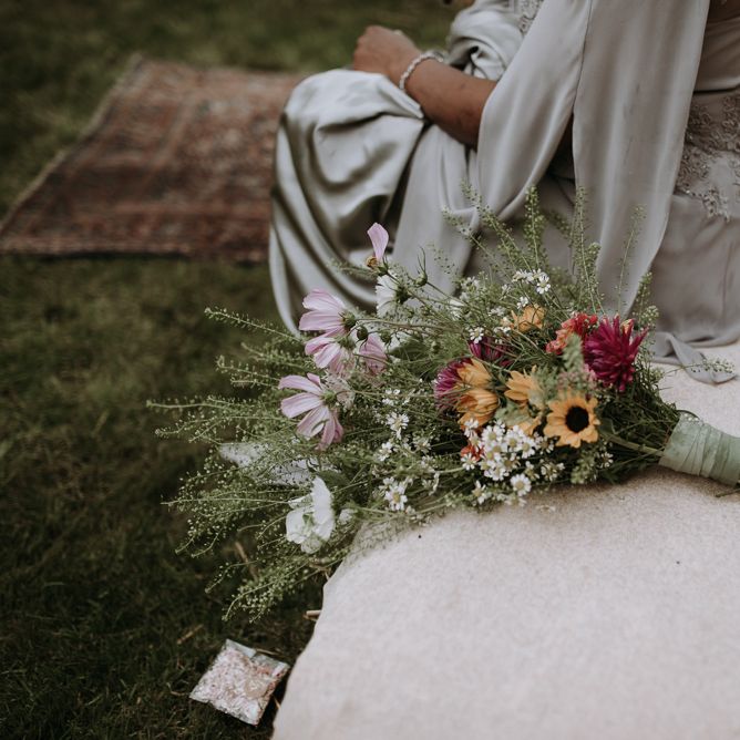 Wildflower wedding bouquet resting on a hay bale