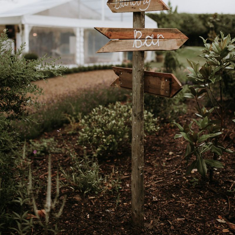 wooden sign post in home garden for wedding celebration