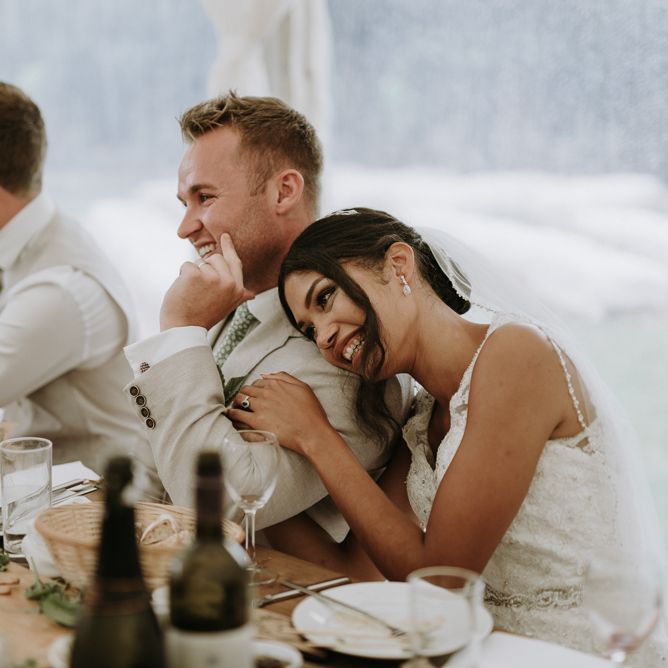 Bride and groom embracing during wedding reception speeches