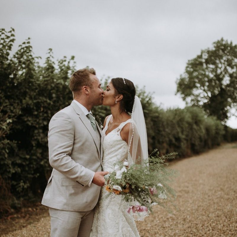 Bride and groom kissing at their home garden for wedding celebration