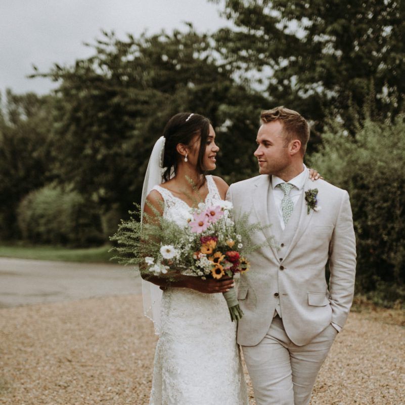 Bride in lace wedding dress and groom in beige suit