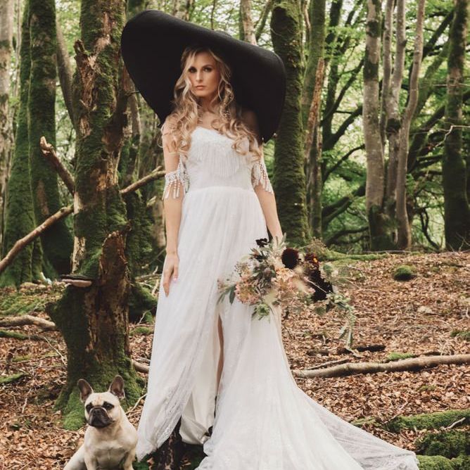 Boho Bride in Cold Shoulder Wedding Dress with Tassels and Giant Black Hat