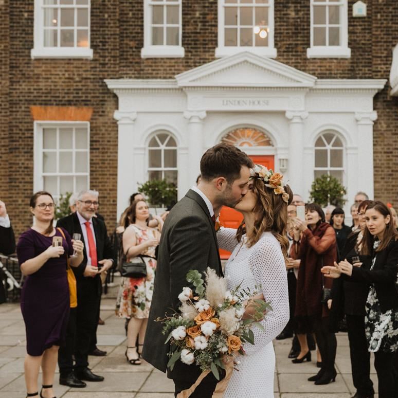 Bride and groom embrace at Linden House ceremony with closest friends and family