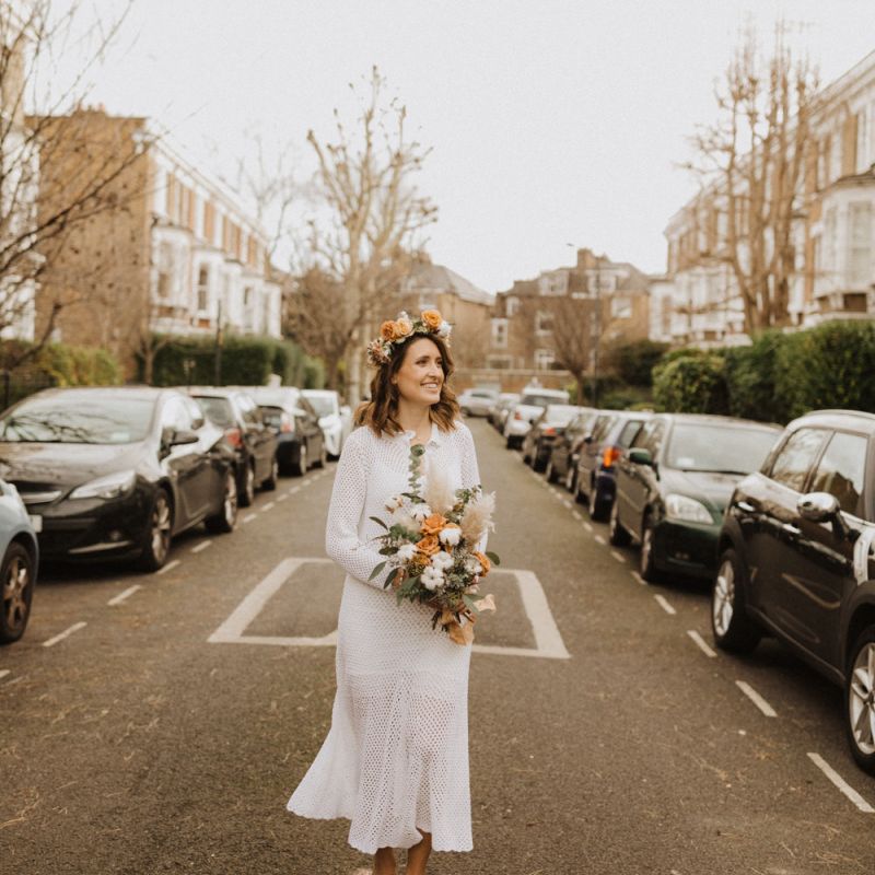 Bride wearing mid length vintage dress with nude heels and floral crown