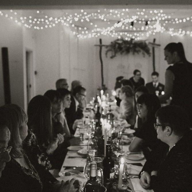 Guests celebrating at Linden House for a intimate and relaxed dinner reception with festoon lighting