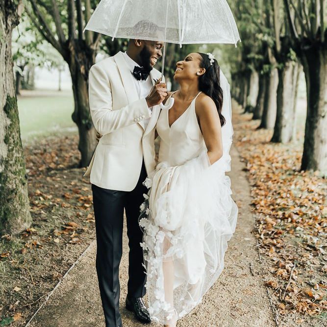 Bride and groom portrait under an umbrella at Coworth Park