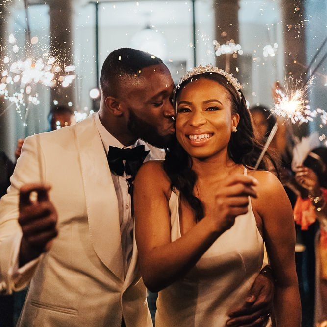 Groom kissing his bride during sparkler exit