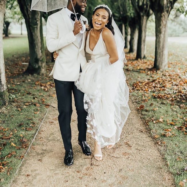 Stylish bride and groom laughing under an umbrella Autumn wedding