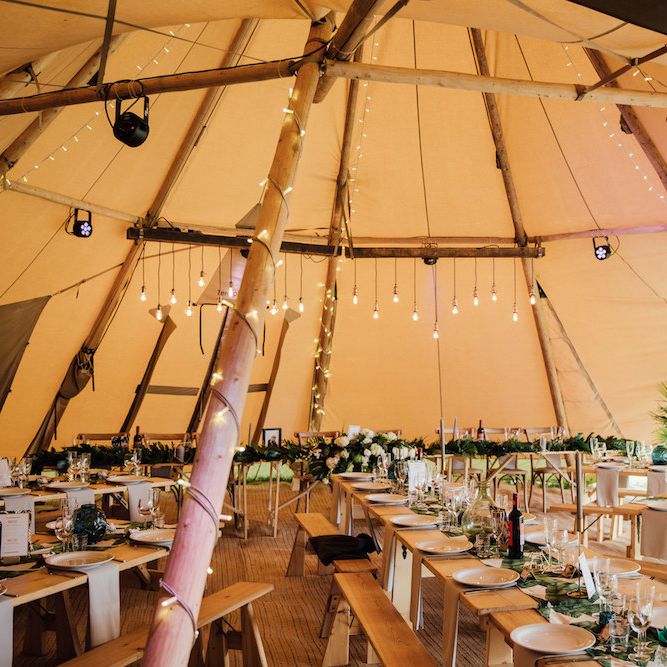 Rustic Tipi Decor with Trestle Tables &amp; Edison Light Installation | Outdoor Wedding Ceremony &amp; Tipi Reception Planned by Benessamy Events | Red on Blonde Photography
