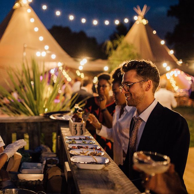 Festoon Lights | Bride in La Sposa Gown from Mirror Mirror Bridal | Groom in Paul Smith Suit | Outdoor Wedding Ceremony &amp; Tipi Reception Planned by Benessamy Events | Red on Blonde Photography