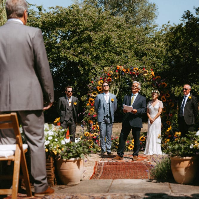 Outdoor Wedding Ceremony with Floral Moon Gate, Bride in Jenny Packham Portia Wedding Dress and Groom in Grey Ted Baker Suit