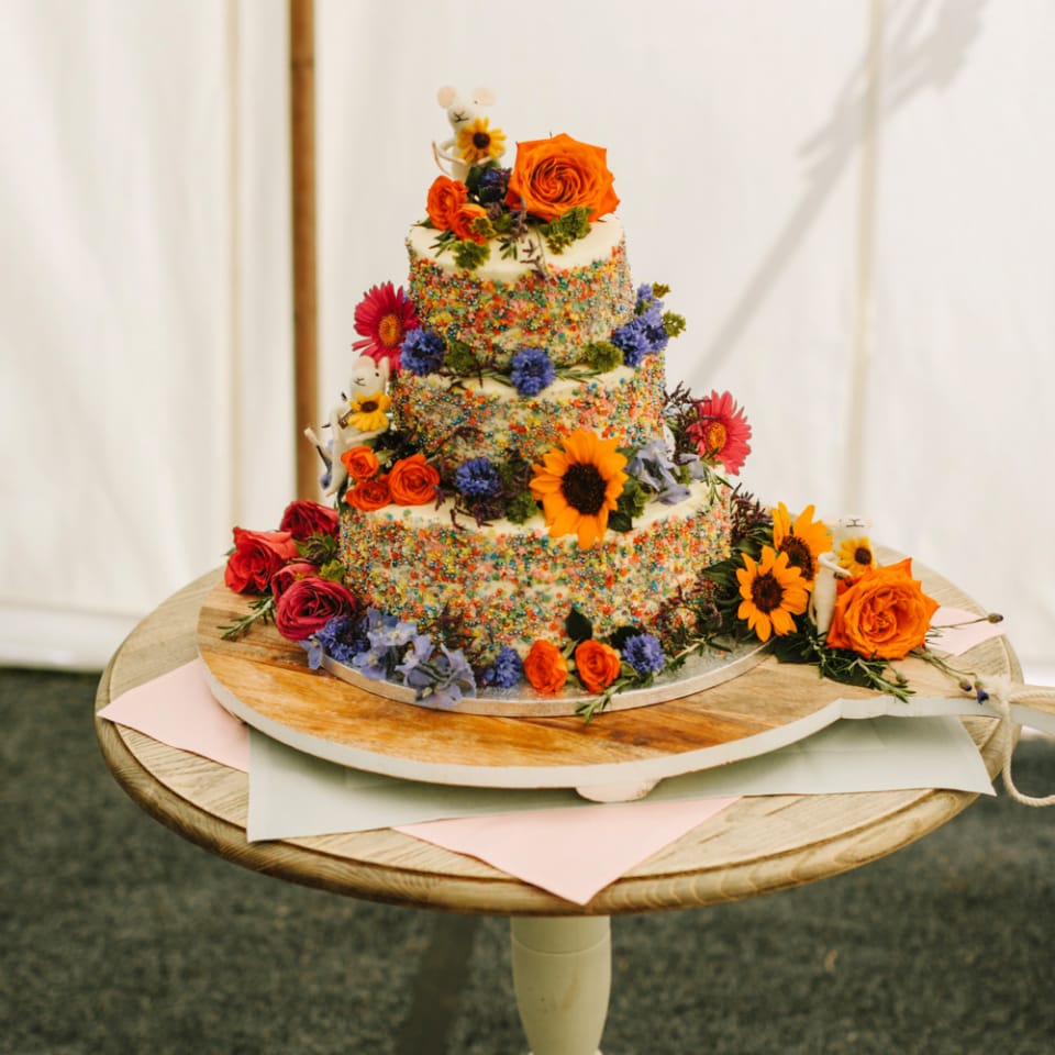 Wedding Cake Covered in Colourful Sprinkles and Flowers