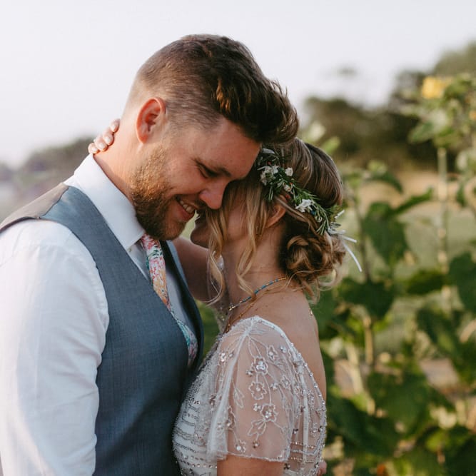 Bride in Jenny Packham Portia Wedding Dress and Flower Crown and Groom in Ted Baker Suit  Embracing in a Sunflower Field