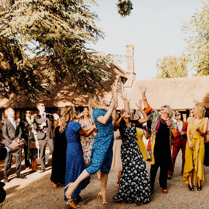 The bride throws the bouquet at village hall wedding in September