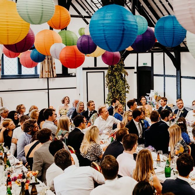 Colourful hanging lanterns decorate the ceiling at village hall reception