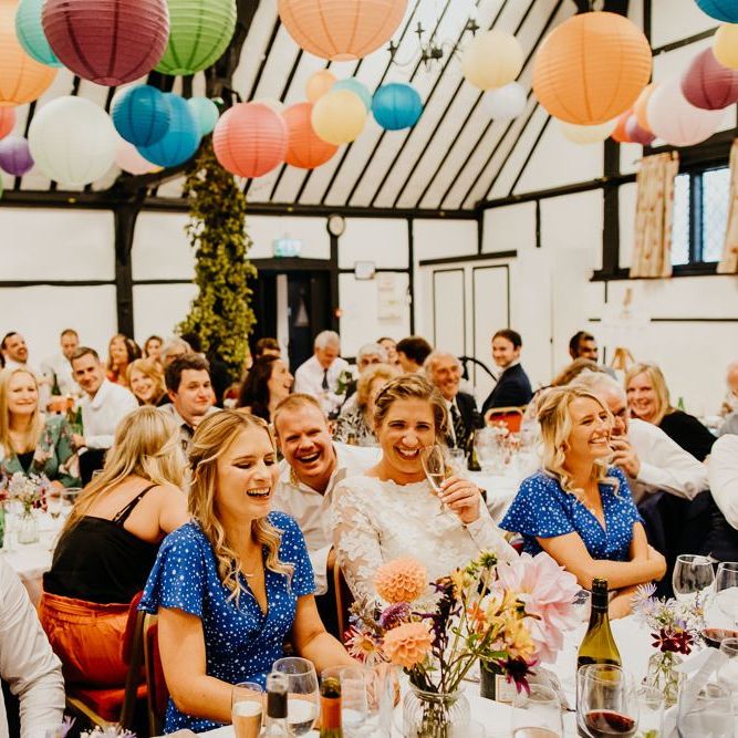 Bright and colourful hanging lanterns decorate the ceiling at village hall wedding